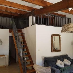 a living room with a staircase and a couch at Maison confortable avec piscine à Saint-Julien-de-la-Nef in Saint-Julien-de-la-Nef