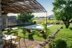 a patio with a table and chairs and a pool at Villa spacieuse à Oppède avec piscine et vue imprenable in Oppède
