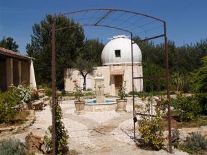 a garden with a white observatory and a building at Appartement T1 "Capella" de l'observatoire in Bauduen