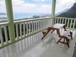 a balcony with a wooden table and two chairs on it at Elegant Villa with Sea View in Victoria in Victoria