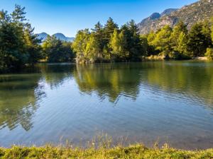 a lake with trees and mountains in the background at Appartement paisible à Saint-Crepin avec vue sur la montagne in Saint-Crépin