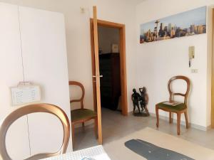 a room with two chairs and a mirror at Charming Apartment in Vibo Valentia with Terrace, 60 m² in Vibo Valentia