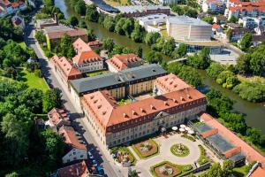 an aerial view of a building with a river at Welcome Hotel Residenzschloss Bamberg in Bamberg