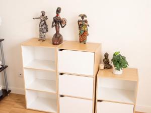 a shelf unit with white and gold shelves at Studio confortable à Pédernec - 27m² - Terrasse ensoleillée in Pédernec +5 photos