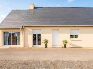 a house with two white doors and two potted plants at Studio confortable à Pédernec - 27m² - Terrasse ensoleillée in Pédernec