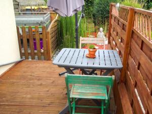 a picnic table and two chairs on a deck at Studio confortable à Pédernec - 27m² - Terrasse ensoleillée in Pédernec