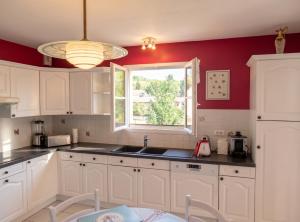 a kitchen with white cabinets and a window at Villa de charme à Ribérac avec piscine privée in Ribérac