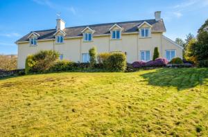 a large house on a grassy hill at Spacious house with sea and mountain views, Co. Kerry in Kells
