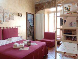a bedroom with a bed with a purple bedspread and a chair at Antica Tibur in Tivoli