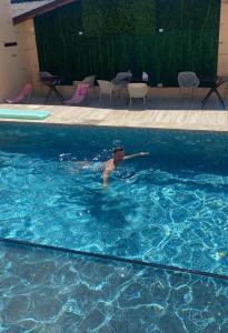 a boy swimming in a swimming pool at Hanul Marioarei in Buneşti