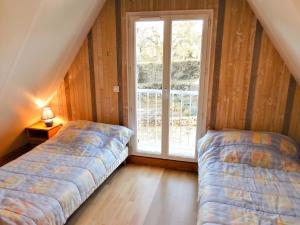 two beds in a room with a window at Villa ravissante à Loubressac avec piscine privée in Loubressac