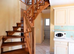 a wooden staircase in a kitchen with a microwave at Villa ravissante à Loubressac avec piscine privée in Loubressac +12 photos