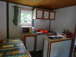 a small kitchen with a stove and a microwave at Bungalow Charmant à Pointe-Noire in Pointe-Noire