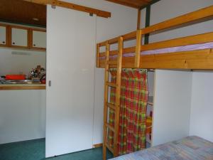 a bedroom with a bunk bed and a kitchen at Bungalow Charmant à Pointe-Noire in Pointe-Noire