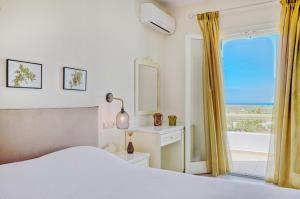 a bedroom with a bed and a window with a view at Spacious house with sea view in Ag. Arsenios, garden in Glinádhon