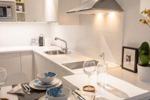 a kitchen with a sink and a table with a wine glass at Charming Apartment in Tías + Pool in Tías
