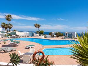 a pool at a resort with the ocean in the background at Charming Apartment in Tías + Pool in Tías