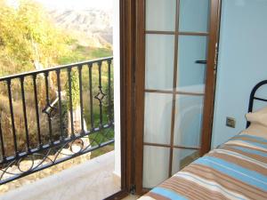 a room with a balcony with a bed and a window at Idyllic House in Yegen with Mountain View in Yegen
