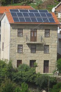 a stone house with solar panels on the roof at Charming Apartment in Alvoco da Serra - Mountain View - 50 sqm in Alvoco da Serra