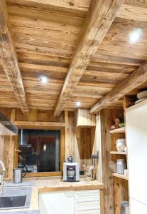 a kitchen with wooden ceilings and a refrigerator at Chalet spacieux à Cordon 180 m² avec vue montagne in Cordon