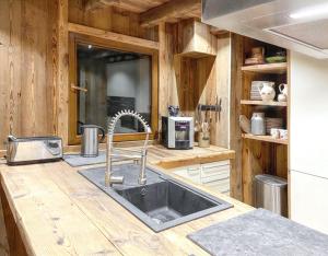 a kitchen with a sink in a wooden kitchen at Chalet spacieux à Cordon 180 m² avec vue montagne in Cordon