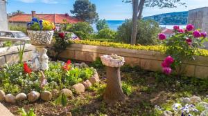 a garden with flowers and a vase in the middle at Comfortable Studio in Sumartin with Sea View - 22 m² in Sumartin