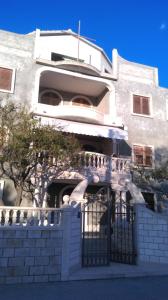 a white building with a gate in front of it at Comfortable Studio in Sumartin with Sea View - 22 m² in Sumartin