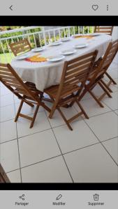 a table with two chairs and a white table cloth at Appartement charmant à Petit-Canal in Petit-Canal