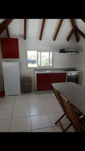 a kitchen with a refrigerator and a table in it at Appartement charmant à Petit-Canal in Petit-Canal