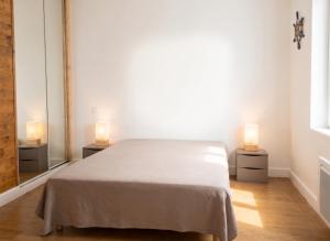 a bedroom with a bed and two lamps on two tables at Maison chaleureuse à Erquy avec jardin et parking in Erquy