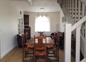 a dining room with a table and chairs and a staircase at Maison chaleureuse à Erquy avec jardin et parking in Erquy