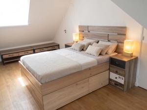 a bedroom with a large wooden bed with two lamps at Maison chaleureuse à Erquy avec jardin et parking in Erquy +5 photos