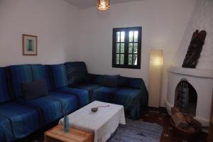 a living room with a blue couch and a fireplace at Spacious Villa in Conil de Frontera with Private Pool in Roche