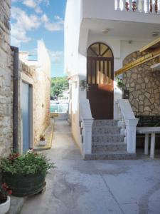 a house with stairs and a door in a courtyard at Sea View Apartment in Prvić Luka, 46m², Terrace in Prvić Luka