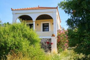 a small house with a gate and bushes at Picturesque Villa in Limnos + Enclosed Garden + Sea View in Lemnos