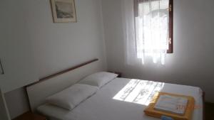 a bedroom with a white bed with a window at Charming Apartment in Gdinj + Garden in Gdinj