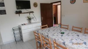 a dining room with a table and chairs and a television at Charming Apartment in Gdinj + Garden in Gdinj