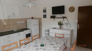 a kitchen with a table and a kitchen with a refrigerator at Charming Apartment in Gdinj + Garden in Gdinj