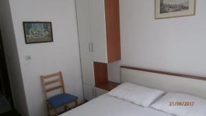 a small bedroom with a bed and a chair at Charming Apartment in Gdinj + Garden in Gdinj