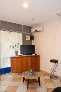 a living room with a tv and a coffee table at Appartement confort au Diamant 25 m² terrasse in Le Diamant
