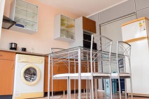 a kitchen with a table and chairs and a washing machine at Appartement confort au Diamant 25 m² terrasse in Le Diamant