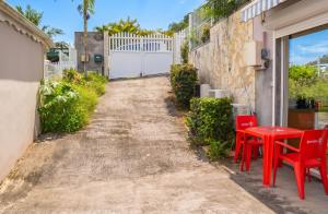 a patio with red tables and chairs next to a building at Appartement confort au Diamant 25 m² terrasse in Le Diamant