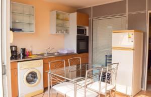 a kitchen with a glass table and a dishwasher at Appartement confort au Diamant 25 m² terrasse in Le Diamant +10 photos