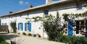 a white house with blue shutters on it at Maison de charme à Saint-Vincent-la-Châtre avec piscine partagée in Saint-Vincent-la-Châtre