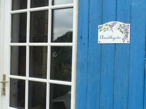 a blue door with a sign on it next to a window at Maison de charme à Saint-Vincent-la-Châtre avec piscine partagée in Saint-Vincent-la-Châtre +13 photos