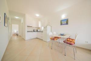 a kitchen with a table and chairs and a refrigerator at Bright Apartment in Vrsi with Terrace and Garden, 65 m² in Vrsi