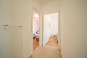 a white room with a hallway with a bedroom at Bright Apartment in Vrsi with Terrace and Garden, 65 m² in Vrsi
