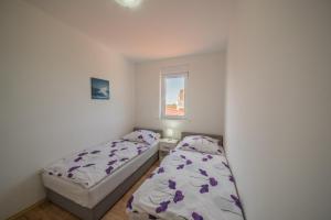 a small bedroom with two beds and a window at Bright Apartment in Vrsi with Terrace and Garden, 65 m² in Vrsi