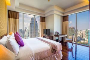 a hotel room with a bed and a large window at Column Bangkok Hotel in Bangkok