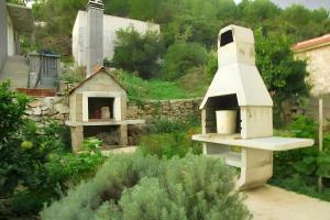 a garden with a bird house and a stone wall at Charming Apartment with Sea View, Gdinj, 70 m², Garden in Gdinj